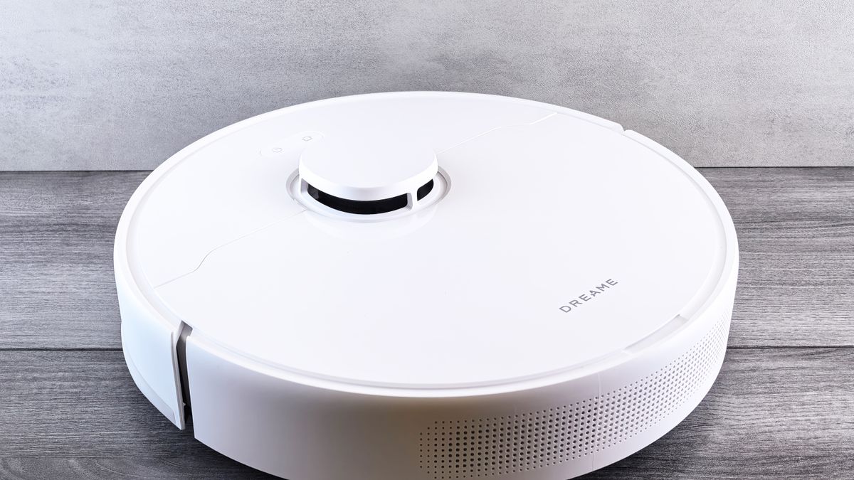 White robot vacuum cleaner standing on a wood floor